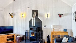 A living room with a fireplace, television, sofa, and wooden furniture. - 2 bedroom accommodation in Ardentinny near Dunoon (Ardentinny near Dunoon)