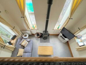 Ein gemütliches Interieur mit einer Couch, einem kleinen Tisch, einem Holzschrank und einem Kamin.