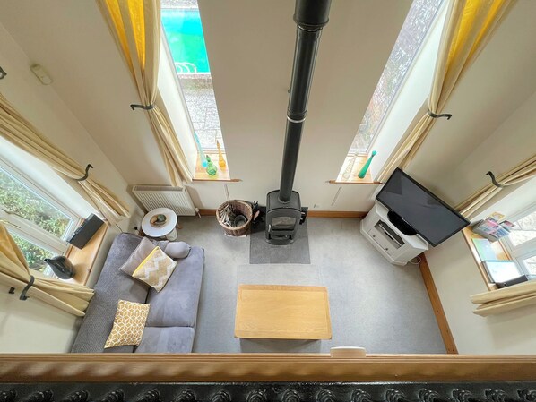 Ein gemütliches Interieur mit einer Couch, einem kleinen Tisch, einem Holzschrank und einem Kamin.