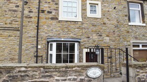 A stone building with a sign indicating private parking. - 2 bedroom accommodation in Skipton (Skipton)