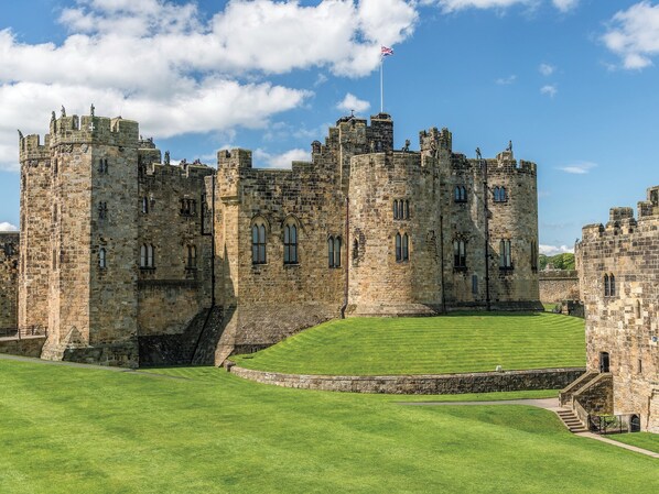 A historic castle with multiple towers and a flagpole.