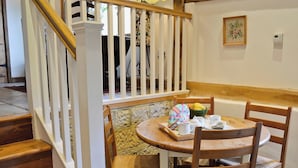 A dining area with a round table, chairs, and a tray with cups and a bowl of fruit. - 2 bedroom accommodation in Burwash (Burwash)