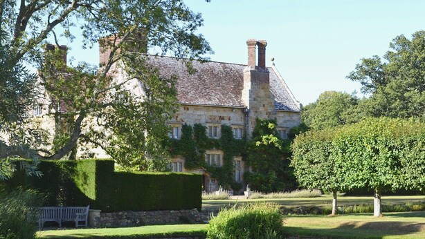 A large stone building with a pond in front, surrounded by well-maintained lawns and trees. - 2 bedroom accommodation in Burwash (Burwash)