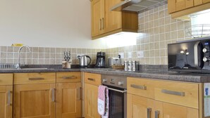 A kitchen with wooden cabinets, a stainless steel sink, a microwave, and a toaster.