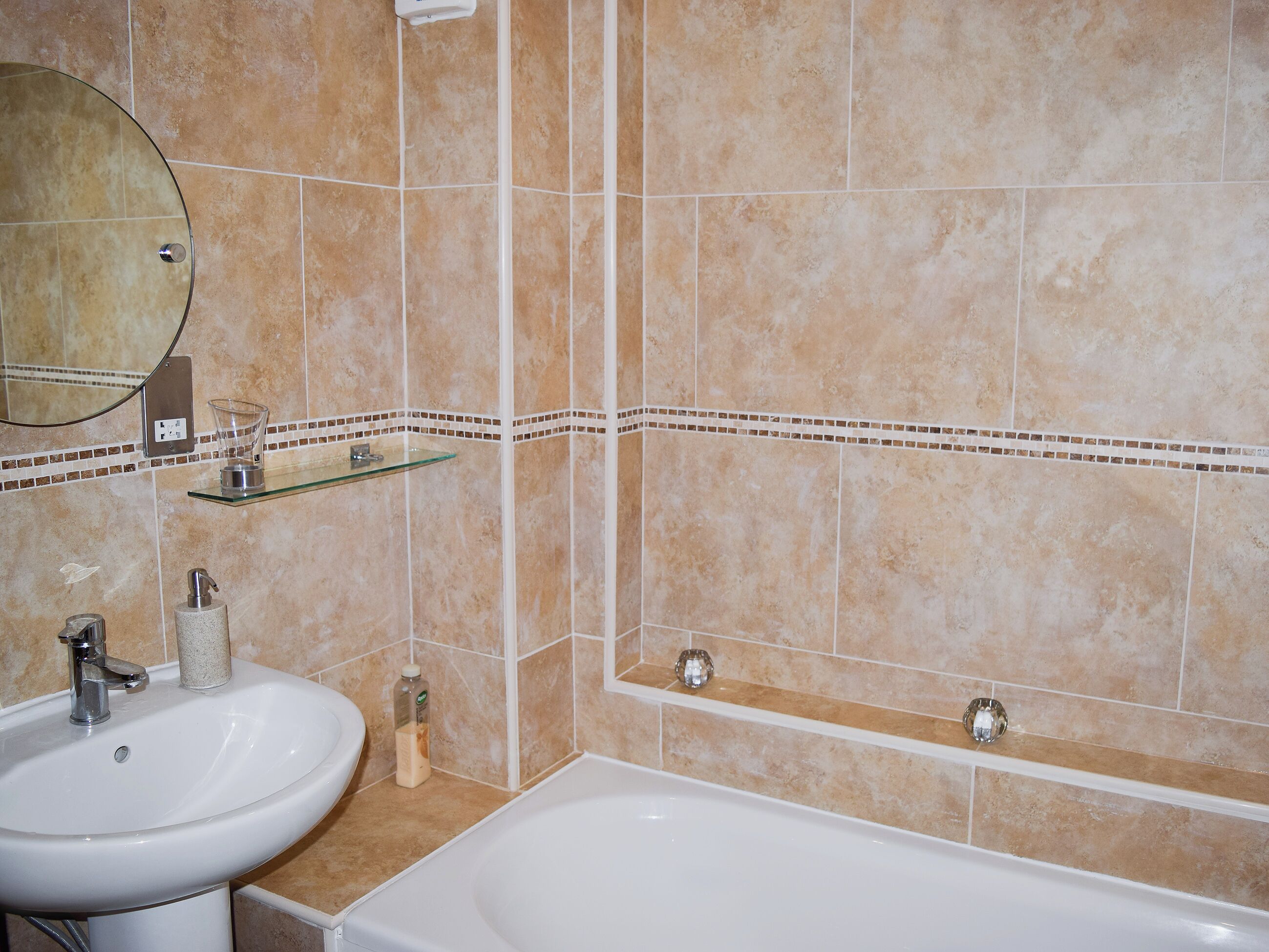 Un bagno con lavandino, specchio e vasca da bagno.