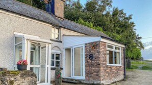 A two-story house with a stone facade, a small brick extension, and a gravel driveway. - 3 bedroom accommodation in Bala (Bala)