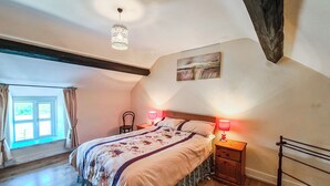 A bedroom with a large bed, wooden floor, a window with curtains, a chandelier, and a painting on the wall. - 3 bedroom accommodation in Bala (Bala)