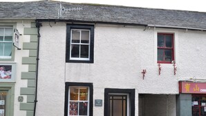 Il s’agit d’un bâtiment à deux étages, à l’extérieur blanc et aux encadrements de fenêtres noirs. Au rez-de-chaussée, une enseigne indique « Uncles 72 Cottage ».