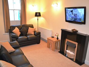Relax in the living room with a comfortable sofa, side table, and fireplace.