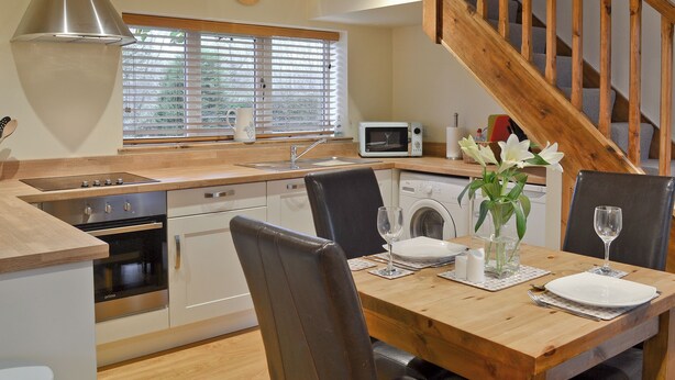 A modern kitchen with a wooden island, built-in oven, microwave, and washing machine. - 1 bedroom accommodation in Ulrome near Bridlington (Ulrome near Bridlington)