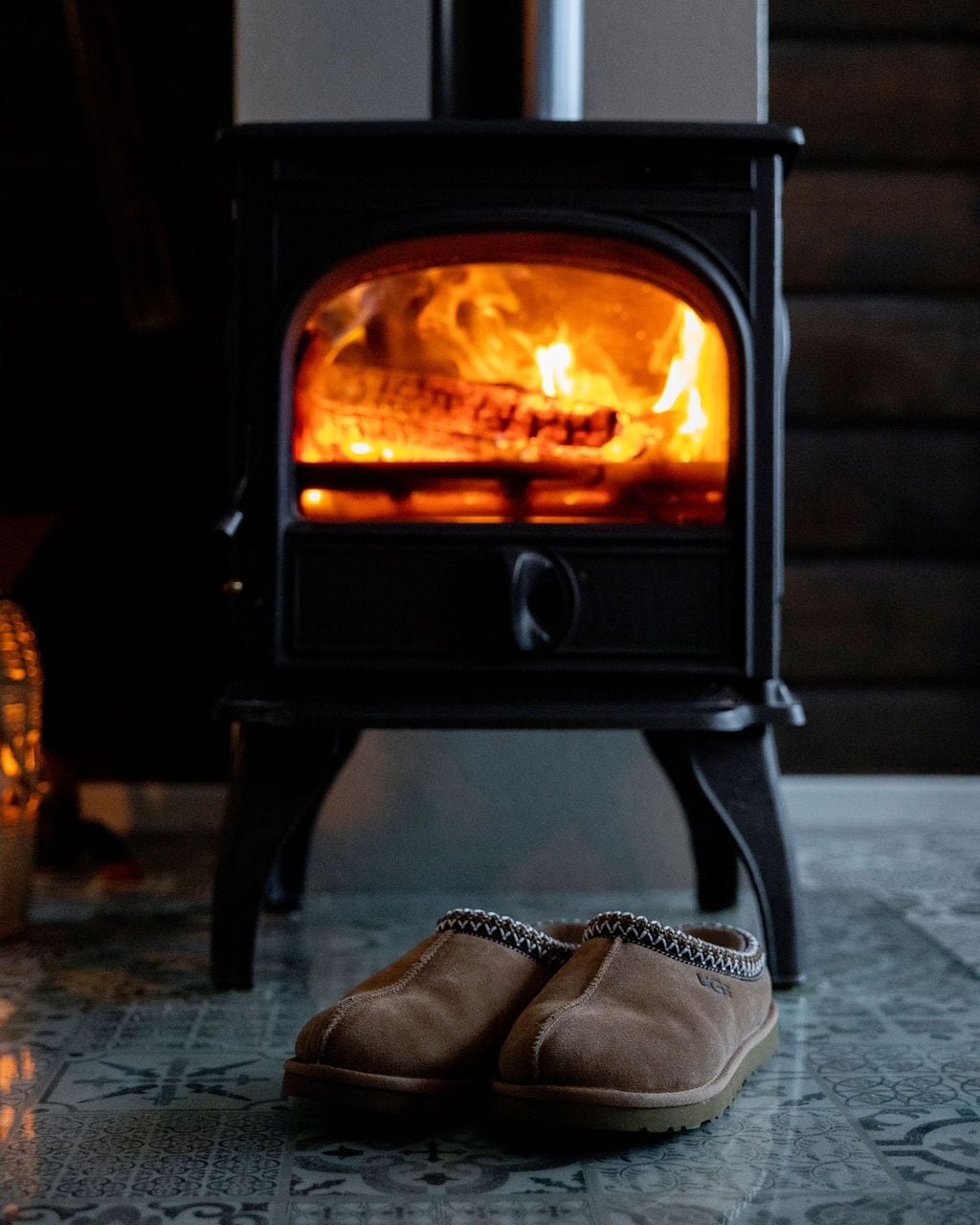 Un poêle à bois avec une paire de chaussures devant.