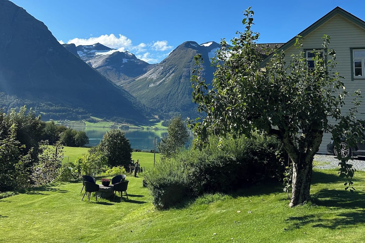 Una casa con vista a montañas y un lago.