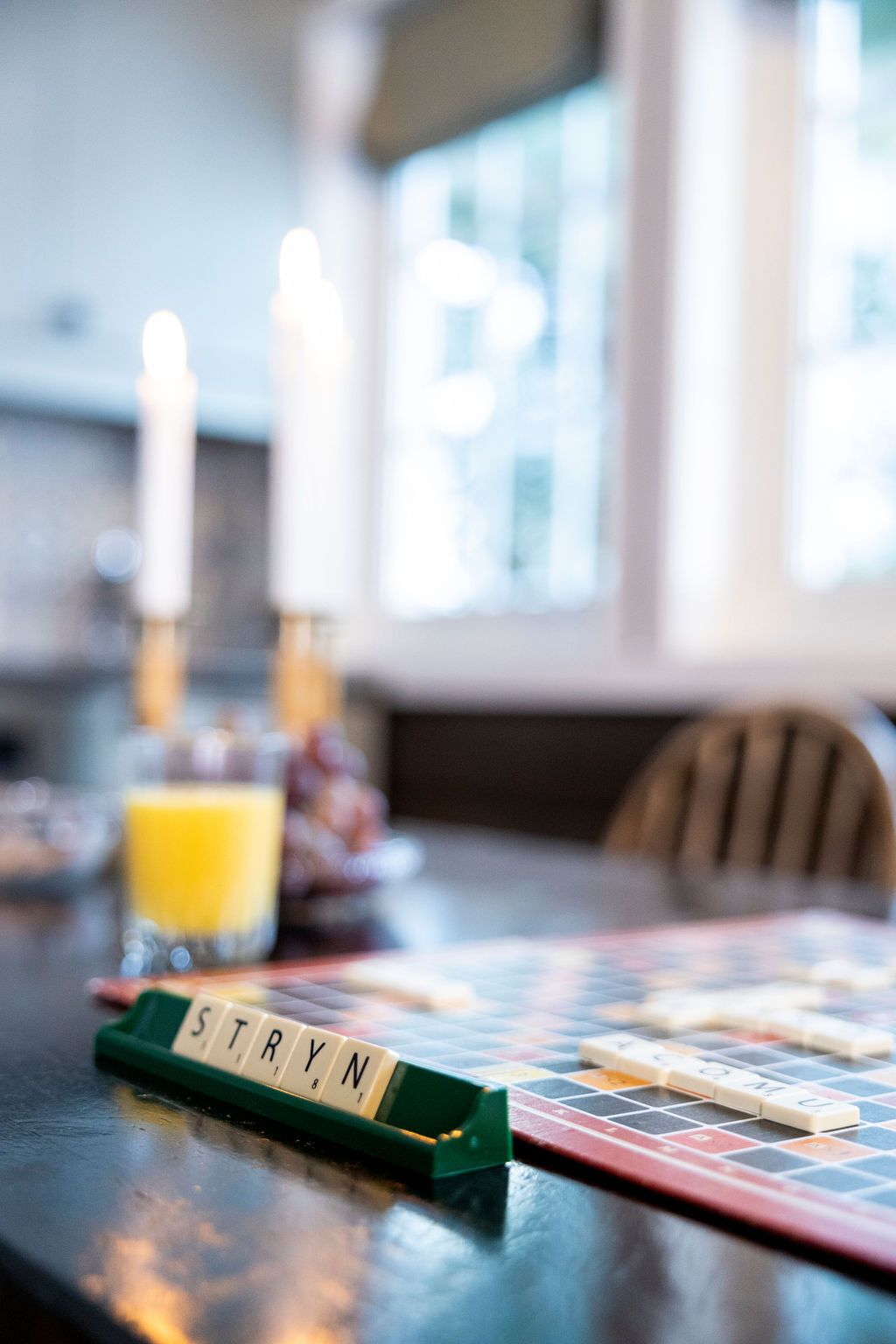 A Scrabble game on a table with a focus on the word 'STRYN'.