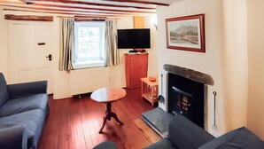 A living room with a fireplace, a television, and two sofas.