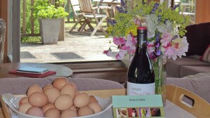 A table with a bowl of eggs, a wine bottle, and a welcome card. - 2 bedroom accommodation in Uplowman, near Tiverton (Uplowman, near Tiverton)