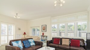 A living room with two brown leather sofas, a white coffee table, and a bookshelf. - 1 bedroom accommodation in Broadstairs (Broadstairs)