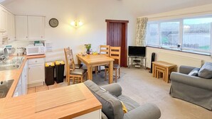 A compact living space with a kitchenette, dining area, and seating area. - 2 bedroom accommodation in Shipton Gorge (Shipton Gorge)