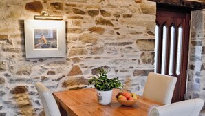 A wooden dining table with chairs, a potted plant, and a bowl of fruit. - Penno Cottage - 24440 (Bodmin)