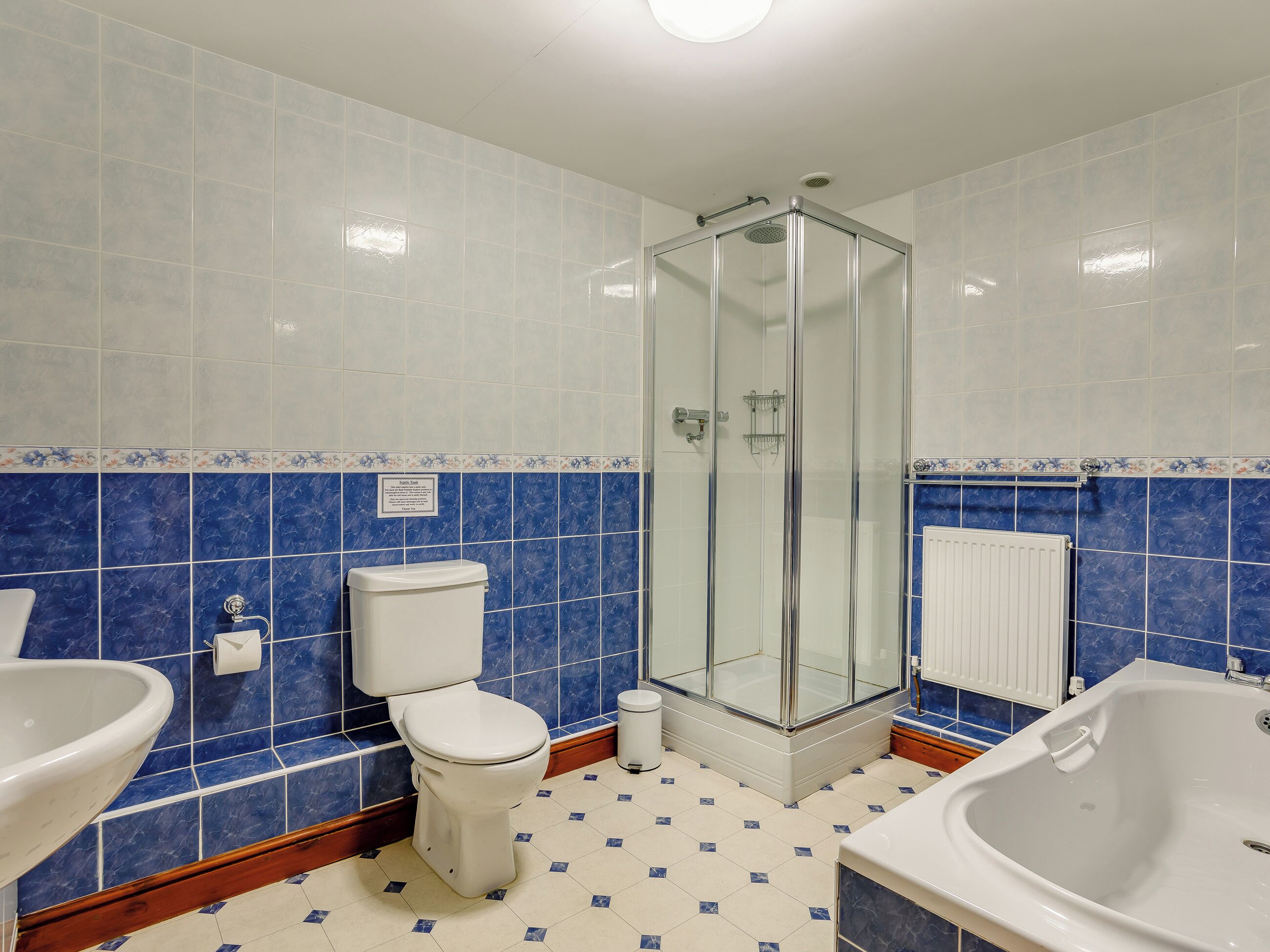 Une salle de bain comprenant des toilettes, un lavabo, une douche et une baignoire.