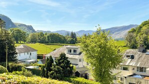A residential area with houses, green fields, and mountains in the background. - A beautiful bungalow, quiet location with beautiful views. (Keswick)