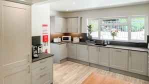 A modern kitchen with grey cabinets, a wooden countertop, and a window with a view of greenery. - A beautiful bungalow, quiet location with beautiful views. (Keswick)