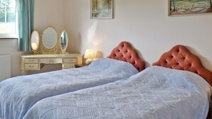 A bedroom with two beds, a dresser, a mirror, and two paintings on the wall. - 1 bedroom accommodation in Apse Heath, near Shanklin (Apse Heath, near Shanklin)