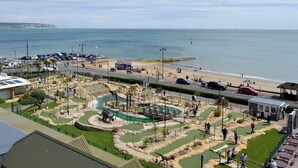 A coastal area with a parking lot, a small building, and a landscaped garden with dinosaur statues. - 1 bedroom accommodation in Apse Heath, near Shanklin (Apse Heath, near Shanklin)