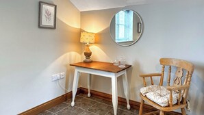 A small room with a wooden table and chair, a lamp, a mirror, and a framed picture on the wall. - The Bran House- 23526 (Hareby, near Horncastle)