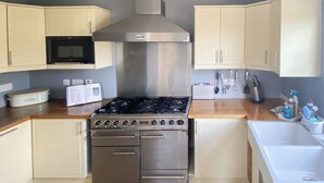 Une cuisine équipée d’une cuisinière, d’un four, d’un four à micro-ondes et de placards.