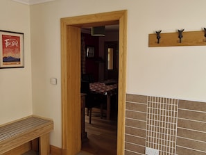 A room with a wooden door, a bench, a tiled wall, and a framed poster on the wall. - 3 bedroom accommodation in Ardgour, near Fort William (Ardgour, near Fort William)