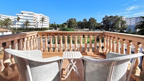 Una terrazza con mobili in vimini e vista sulla città.