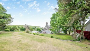 A rural property with a stone house, a grassy lawn, and a red fence. - 7 bedroom accommodation in Portpatrick (Portpatrick)