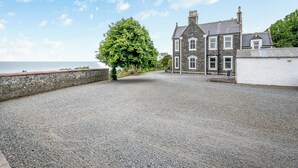 A stone building with a gravel driveway and a tree in front. - 7 bedroom accommodation in Portpatrick (Portpatrick)