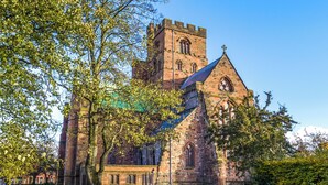 A historic church with a prominent tower and arched windows, surrounded by well-maintained grass and trees. - A delightful little barn conversion situated in a tranquil area of Cumbria. (Ellonby)