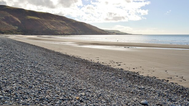 A pebbled beach with a rocky hillside in the background. - 3 bedroom accommodation in Fairbourne (Fairbourne)