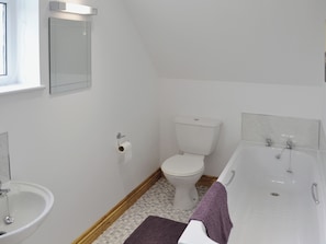 A bathroom with a toilet, sink, and bathtub.