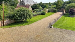 A historic building with a tower, surrounded by well-maintained gardens and a gravel path. - 2 bedroom accommodation in Old Hunstanton (Old Hunstanton)