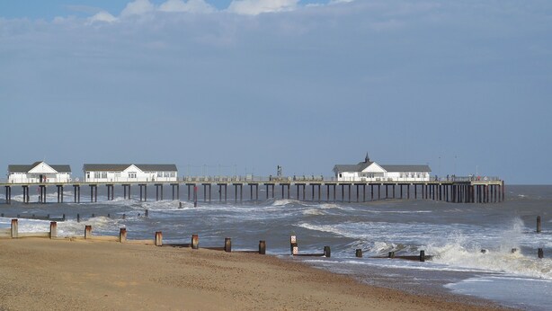 A pier extending into the sea with buildings at the end. - The Wood Shed - E1919 (Hinton, near Dunwich)
