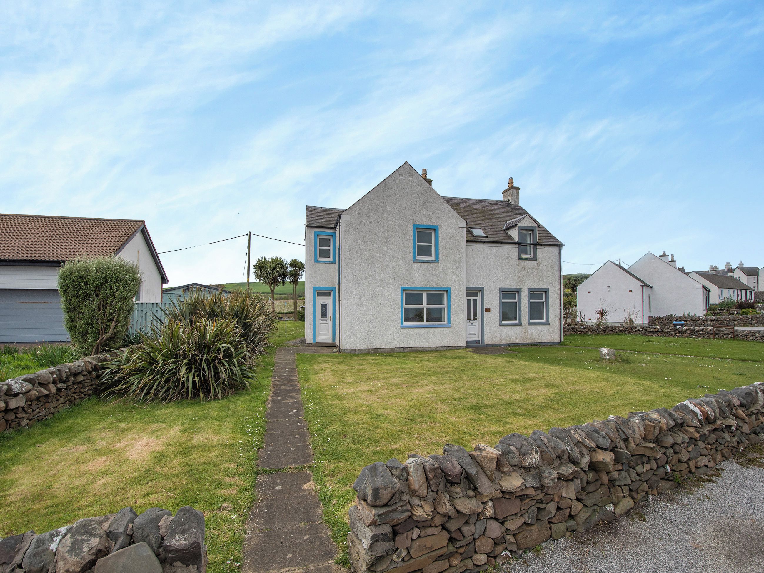 A two-story house with a stone pathway leading to the front door.