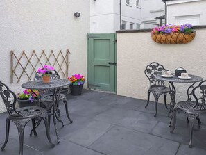 A patio area with outdoor seating and flower planters. - 2 bedroom accommodation in Keswick (Keswick)
