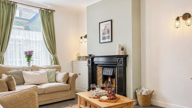 A cozy living room with a sofa, a wooden coffee table, and a fireplace. - 2 bedroom accommodation in Keswick (Keswick)