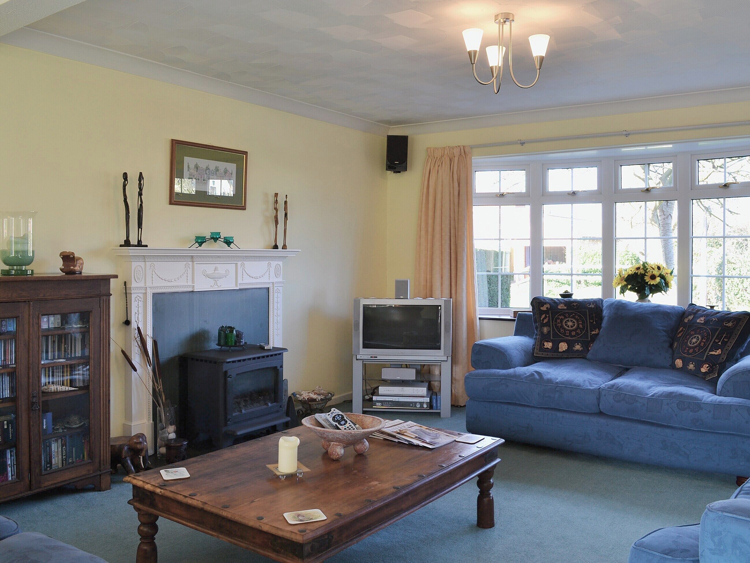A living room with a fireplace, a television, a sofa, and a coffee table.