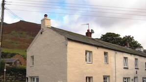 Un bâtiment à deux étages, doté d’une façade blanche et de nombreuses fenêtres. Un panneau est affiché au rez-de-chaussée, indiquant la direction à suivre pour se rendre à Glencathra.