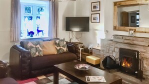A living room with a sofa, a coffee table, a fireplace, and a television. - Bryn Euryn Cottage - 28135 (Rhos-on-Sea, near Colwyn Bay)