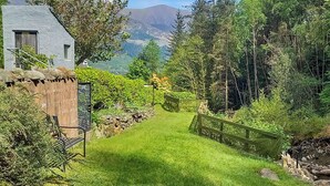 A grassy pathway leading to a rustic building with a stone wall and a wooden fence. - 2 bedroom accommodation in Seldom Seen near Thornthwaite (Seldom Seen near Thornthwaite)