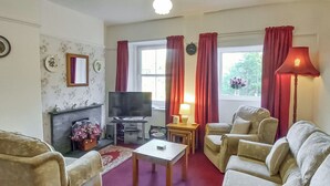 A living room with a fireplace, a television, and a sofa set. - 2 bedroom accommodation in Seldom Seen near Thornthwaite (Seldom Seen near Thornthwaite)