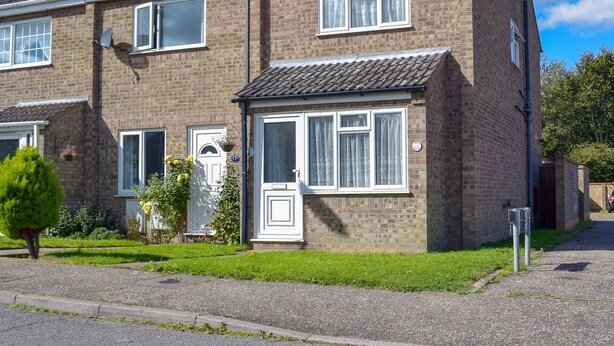 A two-story brick house with a front door, windows, and a small garden. - 2 bedroom accommodation in Hopton-on-Sea, near Great Yarmouth (Hopton-on-Sea, near Great Yarmouth)