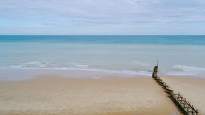 Une plage avec une promenade en bois qui mène à l’eau.