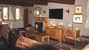 Una sala de estar acogedora con chimenea, televisor y una mesa de centro de madera.