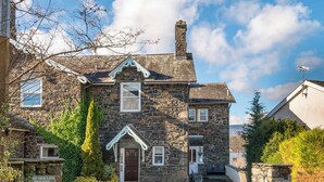 A stone building with a traditional design, a front door, and a sign indicating it is private residents parking. - 1 bedroom accommodation in Keswick (Keswick)